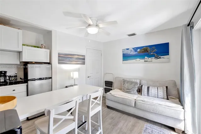 a living room with furniture and kitchen view