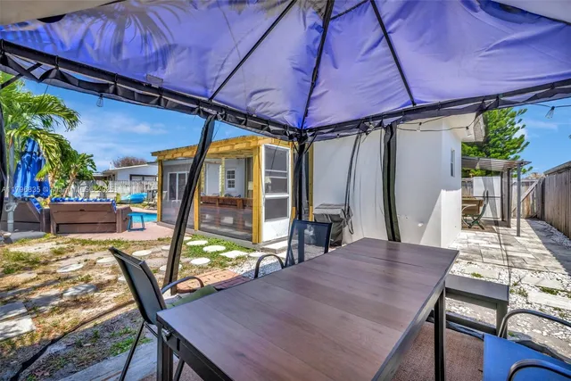 a view of a patio with table and chairs under an umbrella