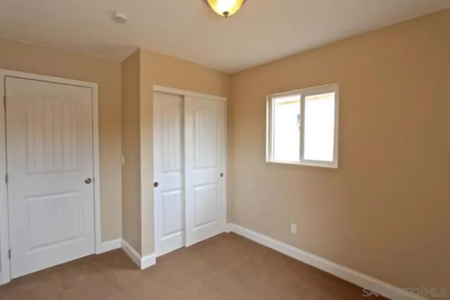 an empty room with windows and closet