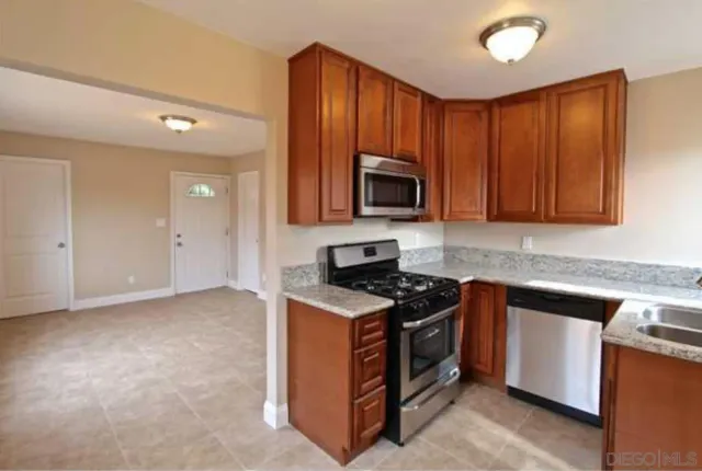 a kitchen with stainless steel appliances granite countertop a stove a sink and a microwave