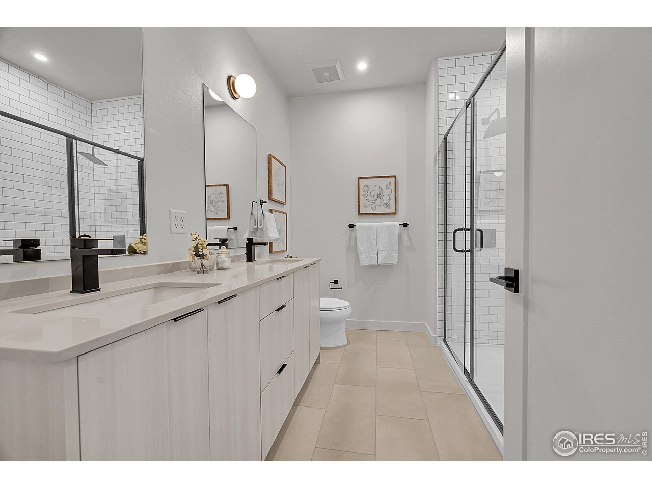 777 East County Line Road Erie, CO 80516 - Photo 10 of 15 a bathroom with a double vanity sink a toilet and a mirror