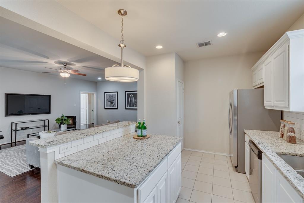 2705 McCart Avenue, Unit 205 Fort Worth, TX 76110 - Photo 15 of 25 a kitchen with granite countertop a sink a counter top space appliances and cabinets