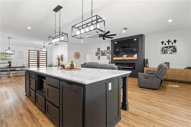 a kitchen with stainless steel appliances granite countertop a kitchen island a stove and a wooden floors