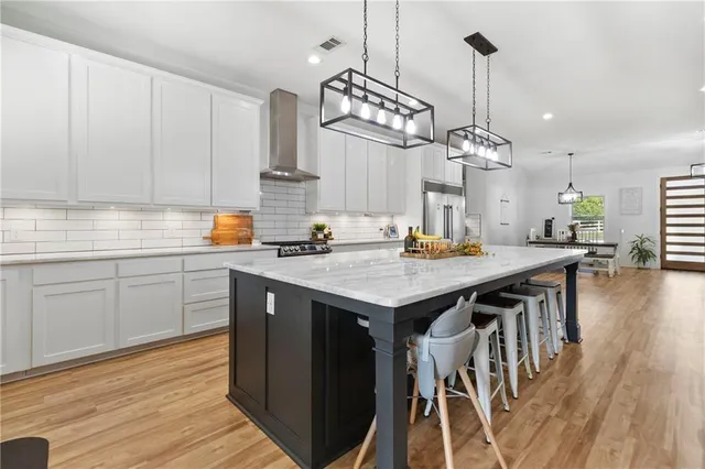a kitchen with wooden floor and chairs