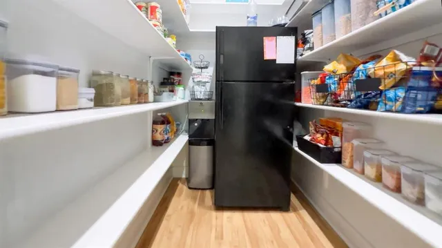 a kitchen with stainless steel appliances a refrigerator and a wooden floor
