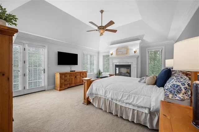 a bedroom with a bed flat screen tv and a fireplace