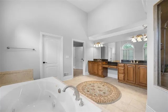 a large bedroom with a large bed a rug and balcony view