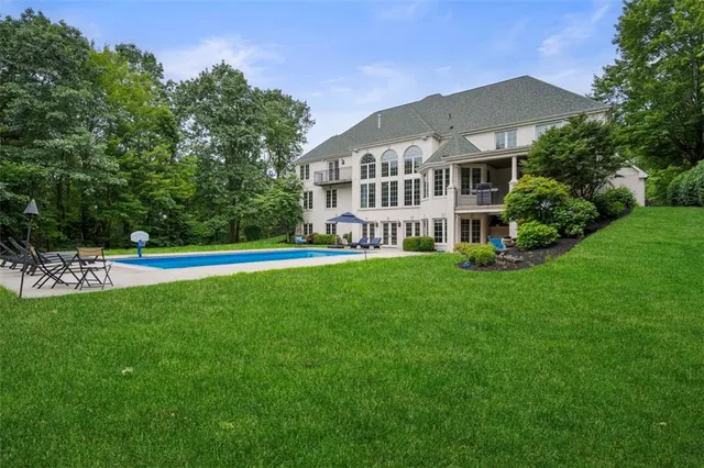 a view of a house with a swimming pool and sitting area