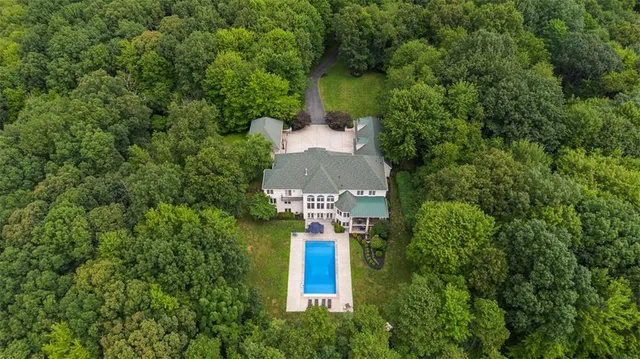 an aerial view of a house with a yard and trees