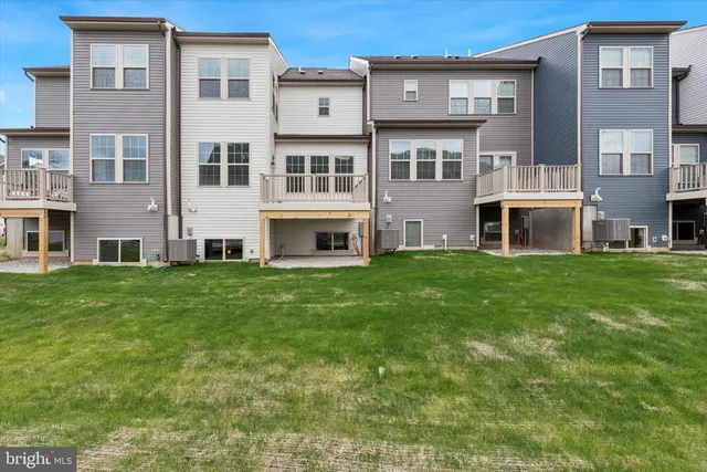 a balcony with wooden floor next to a yard