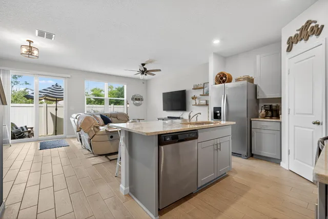 a kitchen with stainless steel appliances a stove refrigerator sink and microwave