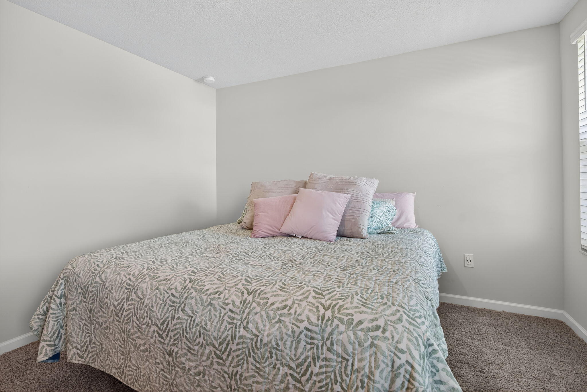 3942 Southeast Caladium Court Stuart, FL 34997 - Photo 22 of 38 a large bed sitting in a bedroom next to a wall