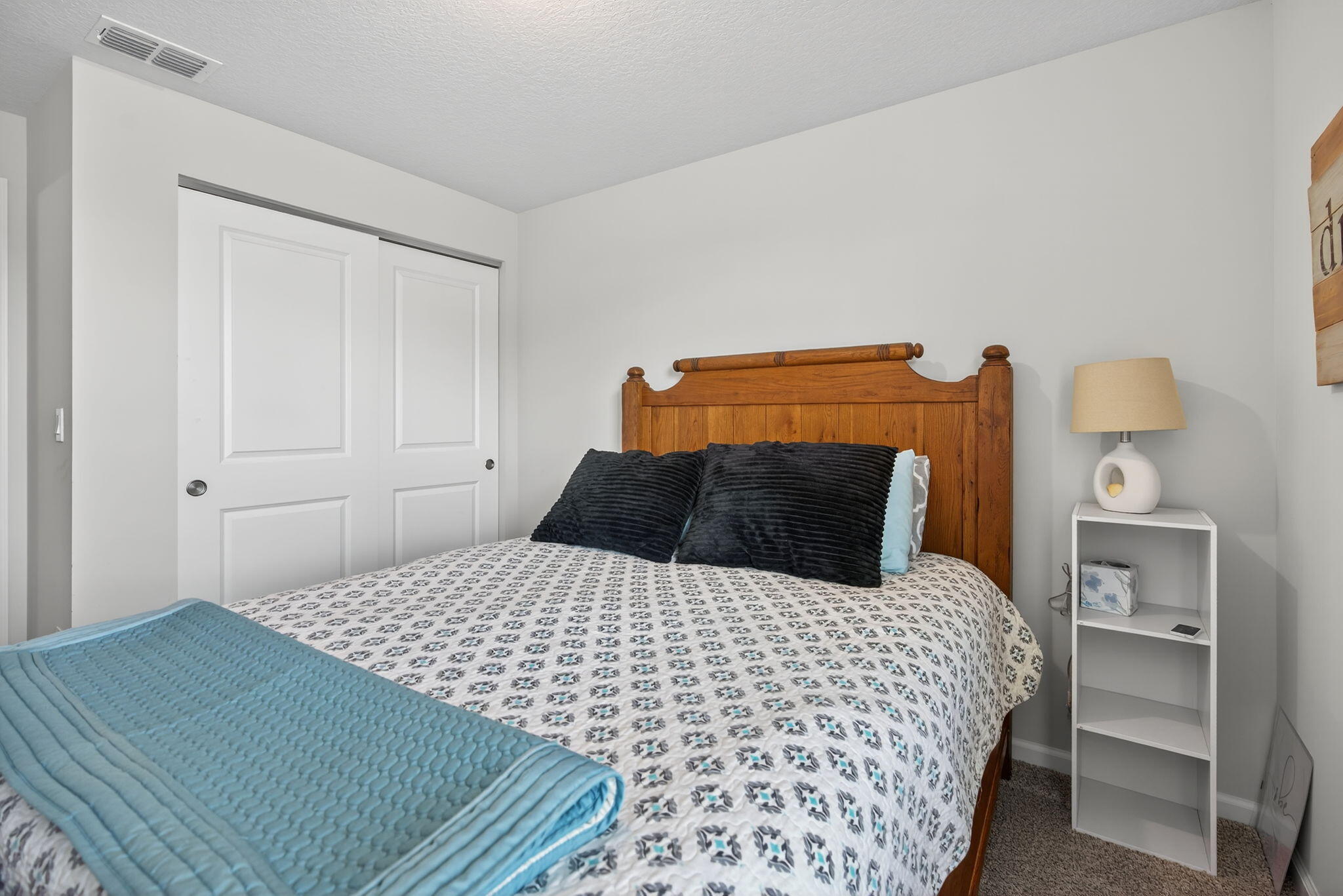 3942 Southeast Caladium Court Stuart, FL 34997 - Photo 26 of 38 a bedroom with a large bed and a lamp