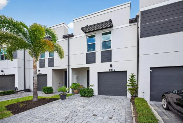 a front view of a house with garden and parking