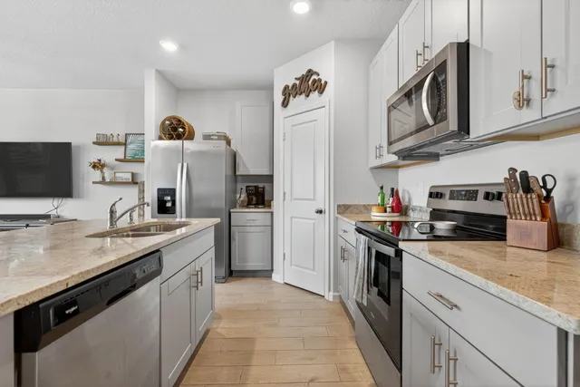 a kitchen with stainless steel appliances granite countertop a sink stove and refrigerator