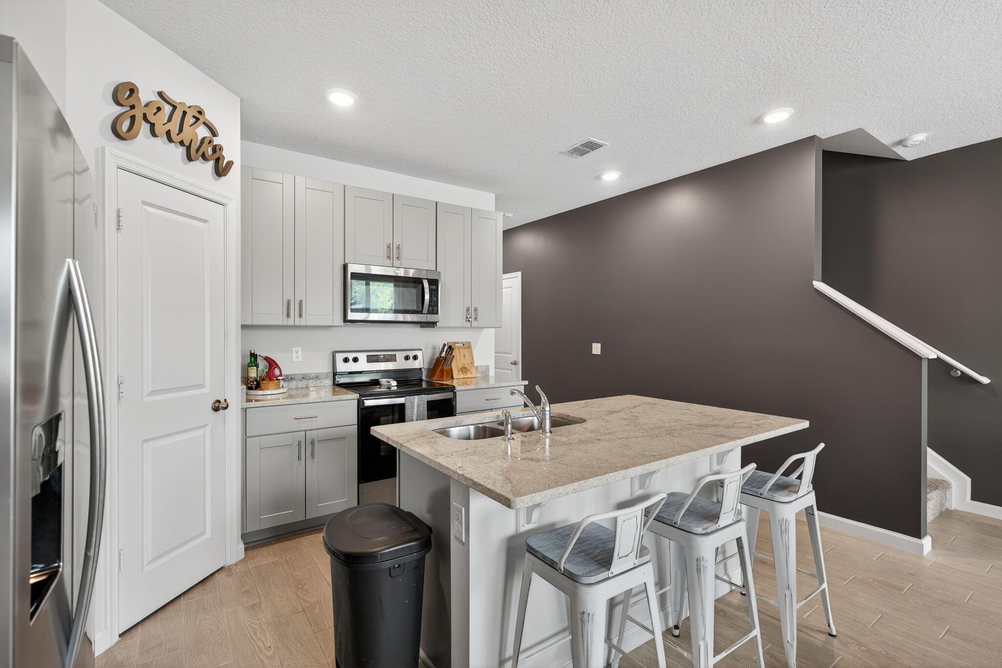 3942 Southeast Caladium Court Stuart, FL 34997 - Photo 10 of 38 a kitchen with stainless steel appliances a white refrigerator a stove a sink and a refrigerator