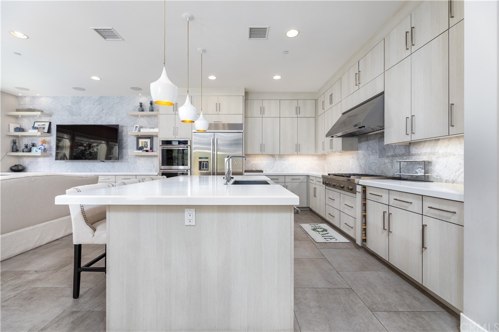 35 Zion Drive Lake Forest, CA 92630 - Photo 8 of 41 a kitchen with kitchen island granite countertop a sink and white cabinets