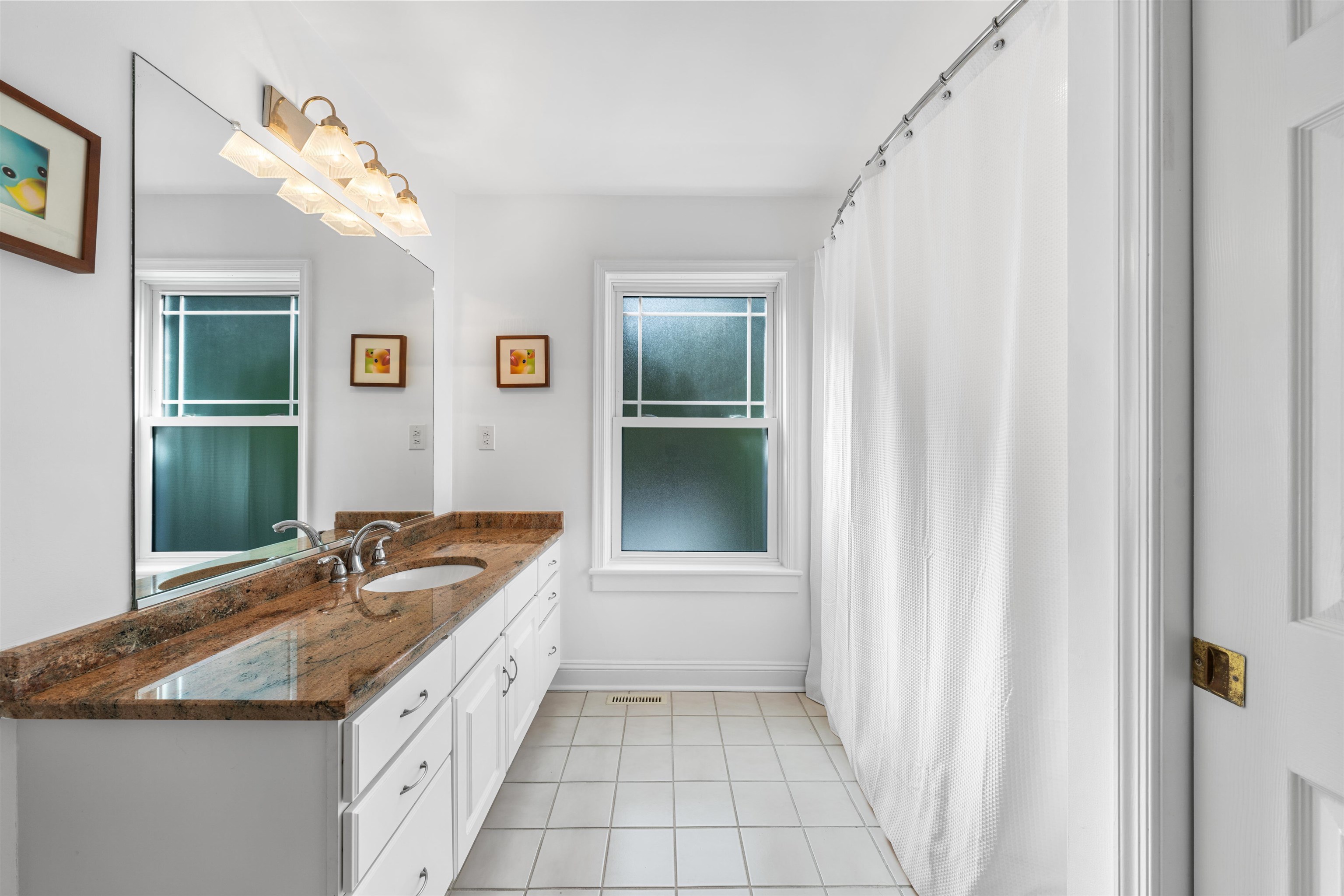 246 103rd Street Stone Harbor, NJ 08247 - Photo 23 of 50 a spacious bathroom with a granite countertop sink a mirror and a bathtub