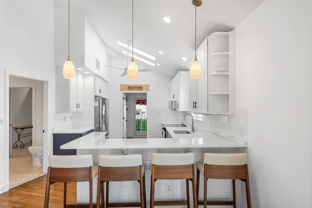 a kitchen with kitchen island granite countertop a sink and chairs