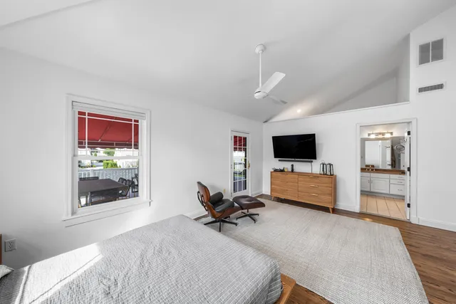 a bedroom with furniture window and flat screen tv