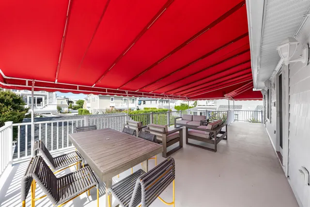 a view of a patio with table and chairs and couches with wooden floor