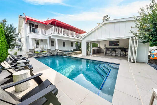 a view of a house with swimming pool and sitting area