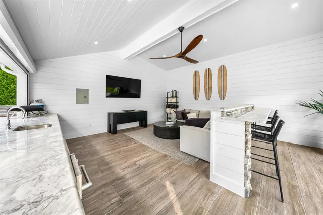 a living room with furniture a flat screen tv and a wooden floor