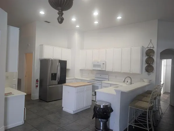 a kitchen with a sink a refrigerator and cabinets