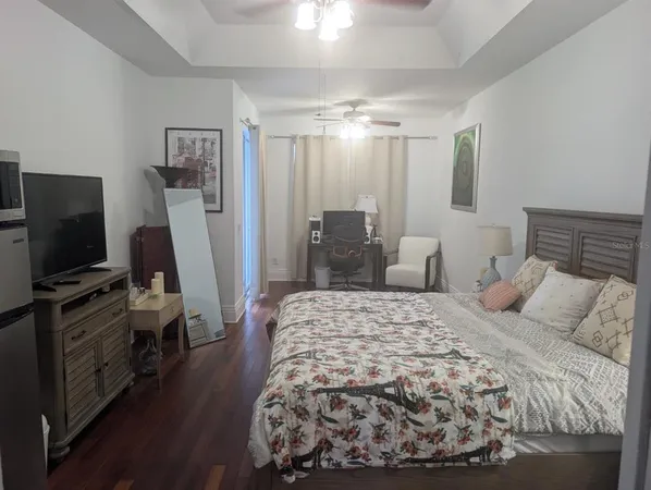 a bedroom with a bed and a flat screen tv