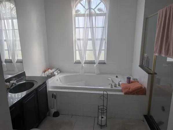 a bathroom with a tub sink and a window