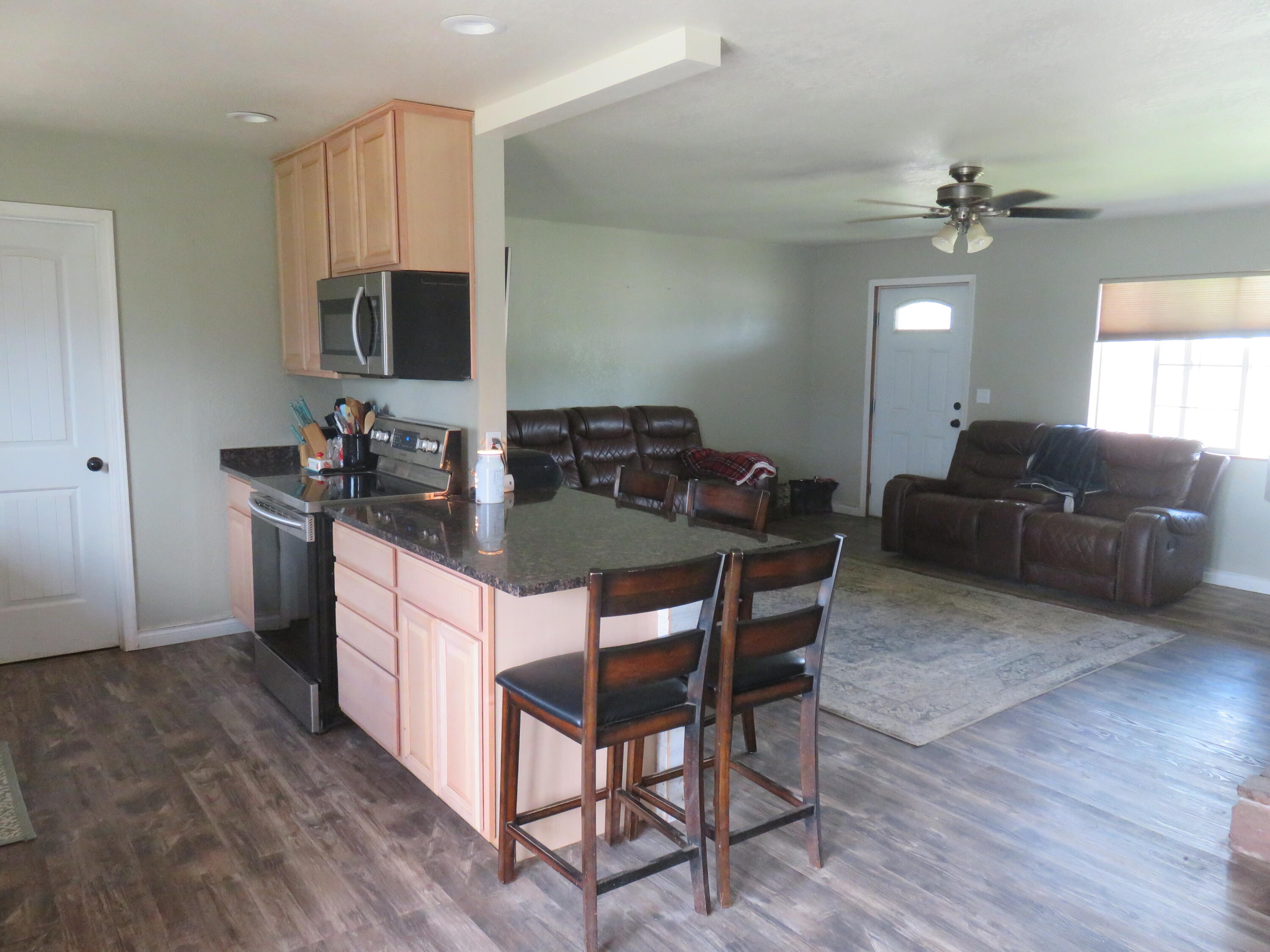 3798 County Road 91 Lookout, CA 96054 - Photo 20 of 54 a kitchen with stainless steel appliances granite countertop a stove a sink dishwasher a dining table and chairs with wooden floor