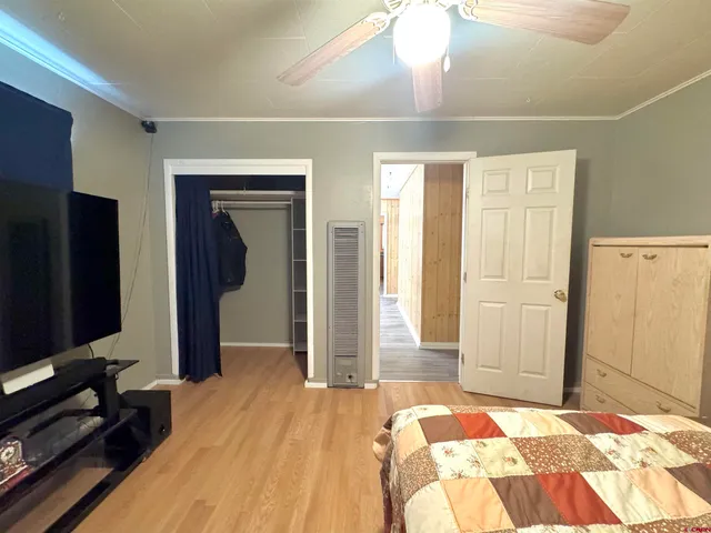 a bedroom with a bed and a flat tv screen on dresser