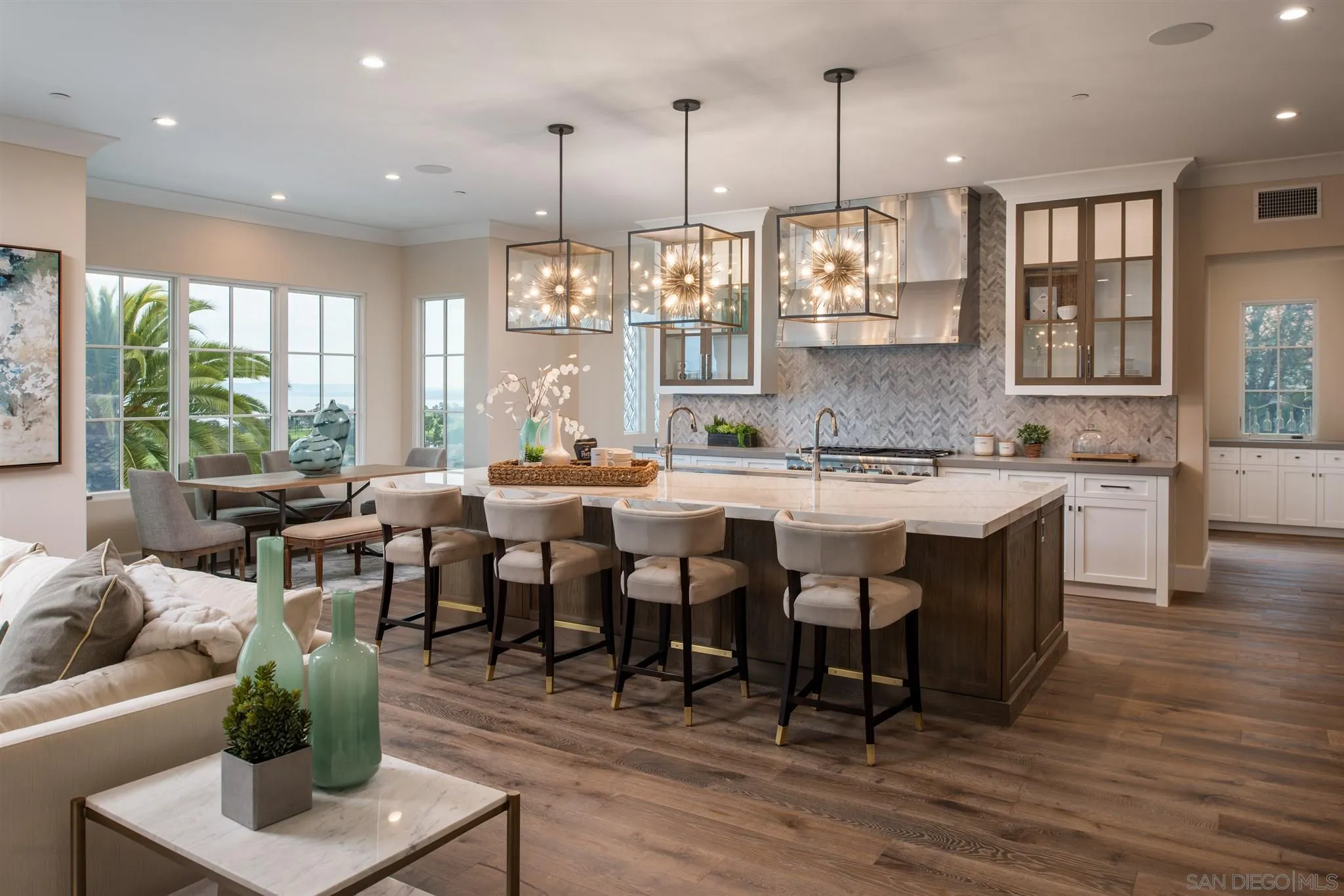 1206 Muirlands Drive La Jolla, CA 92037 - Photo 11 of 75 a dining hall with stainless steel appliances kitchen island granite countertop a table chairs and a living room