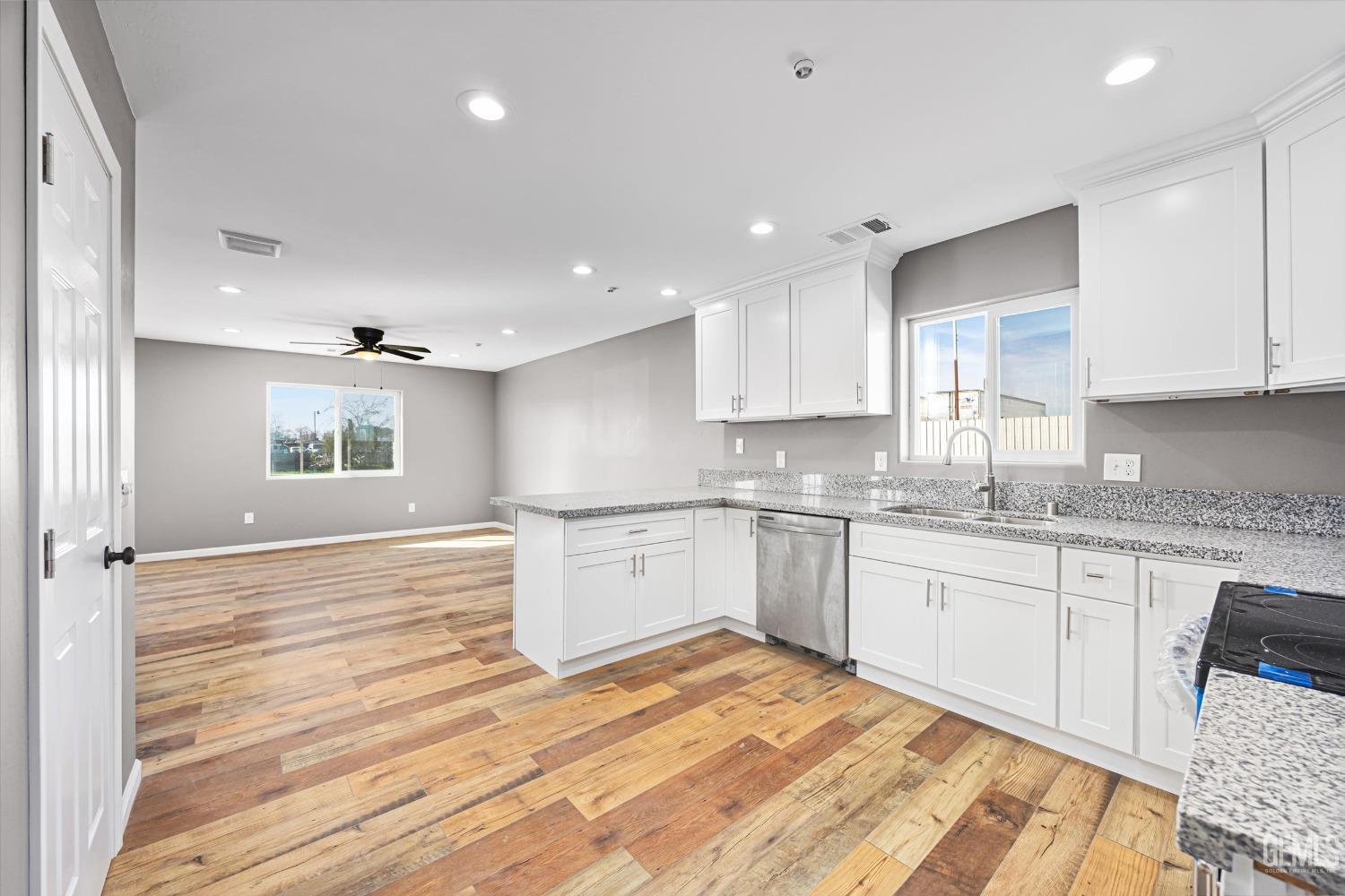 Undisclosed Address Bakersfield, CA 93307 - Photo 13 of 22 a large kitchen with granite countertop a stove and white cabinets