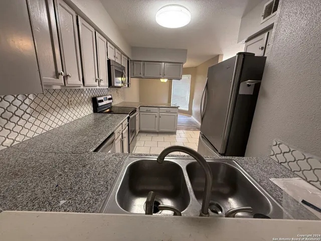 a kitchen with a sink and a refrigerator