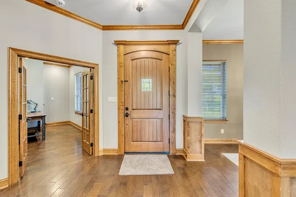 a view of a hallway with wooden floor and staircase