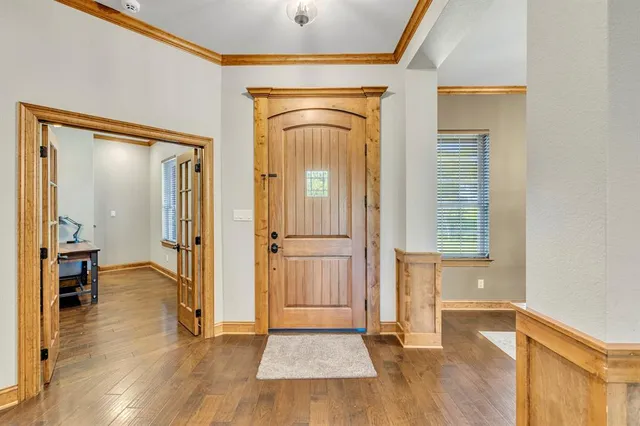 a view of a hallway with wooden floor and staircase