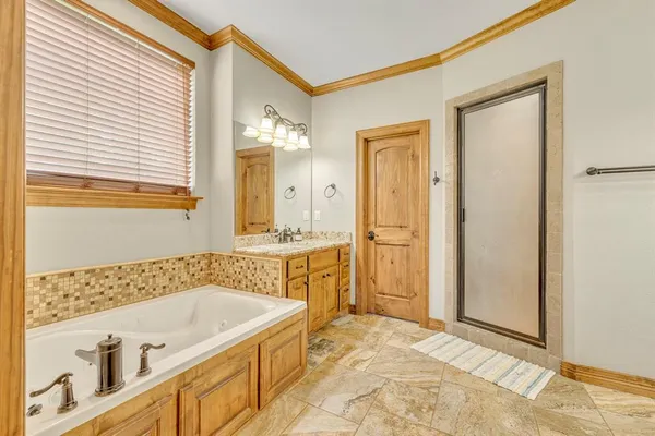 a bathroom with a tub a sink and a mirror
