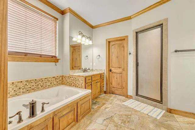 a bathroom with a tub a sink and a mirror