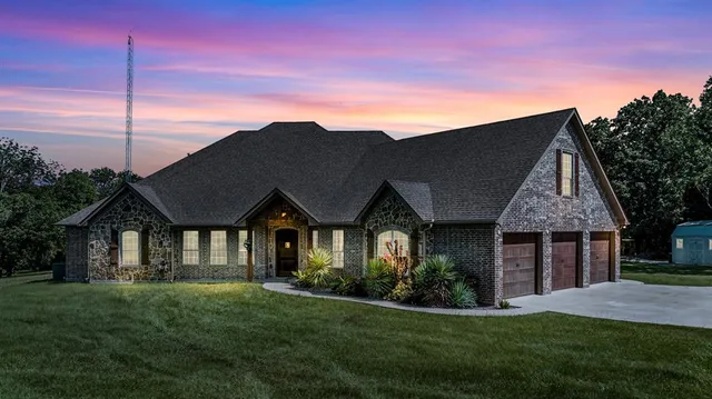 a front view of a house with a garden and yard