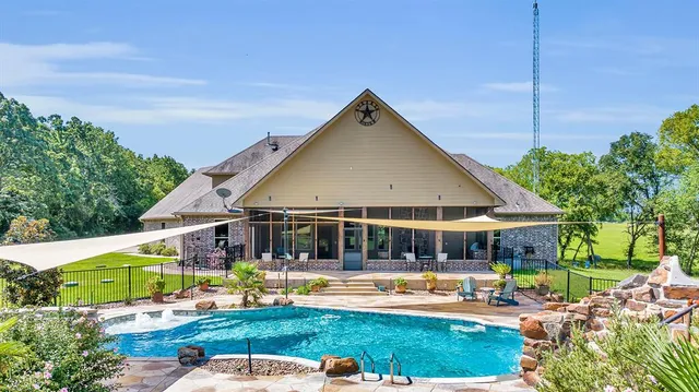 a view of a house with swimming pool and yard