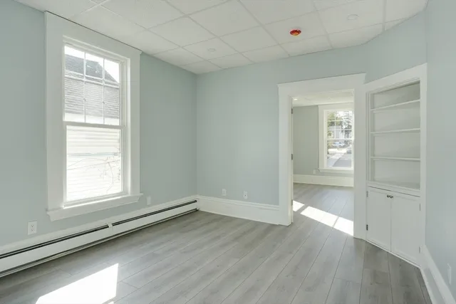 an empty room with wooden floor and windows