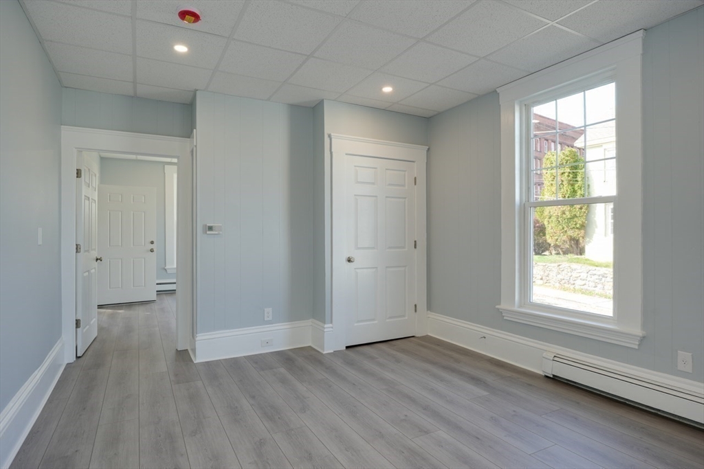 47 Mechanic Street, Unit 1 Marlborough, MA 01752 - Photo 15 of 26 an empty room with wooden floor and windows