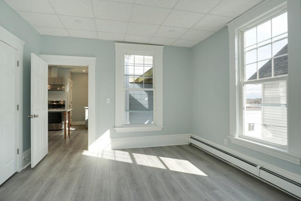 47 Mechanic Street, Unit 1 Marlborough, MA 01752 - Photo 16 of 26 an empty room with wooden floor and windows