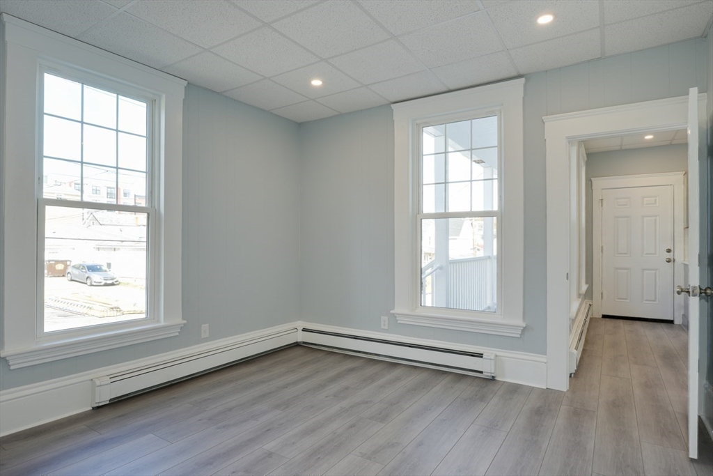 47 Mechanic Street, Unit 1 Marlborough, MA 01752 - Photo 17 of 26 an empty room with wooden floor and windows
