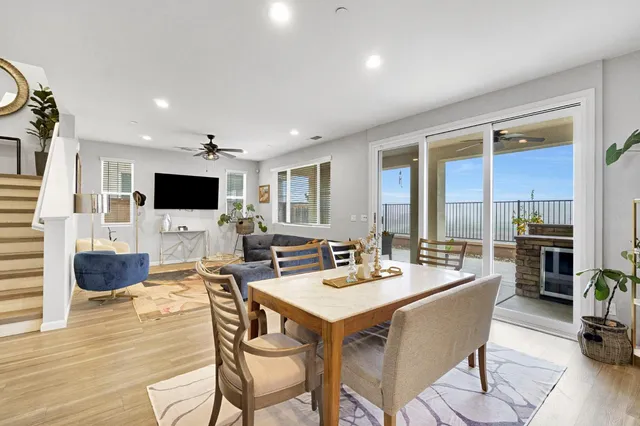 a kitchen with stainless steel appliances granite countertop a refrigerator a sink dishwasher a stove and white cabinets with wooden floor