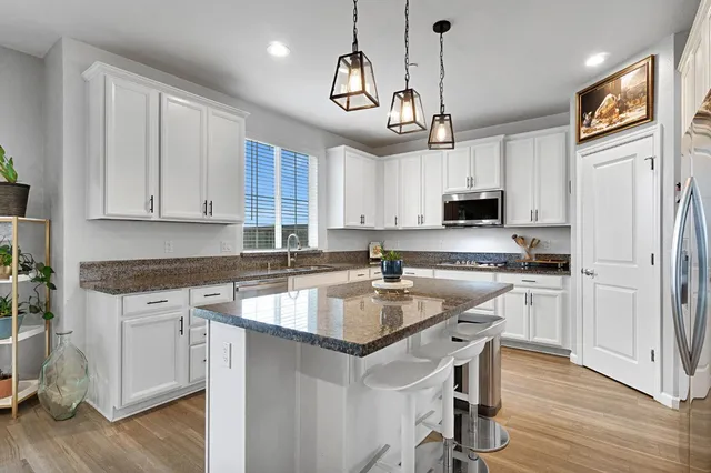 a kitchen with stainless steel appliances granite countertop a sink refrigerator and microwave