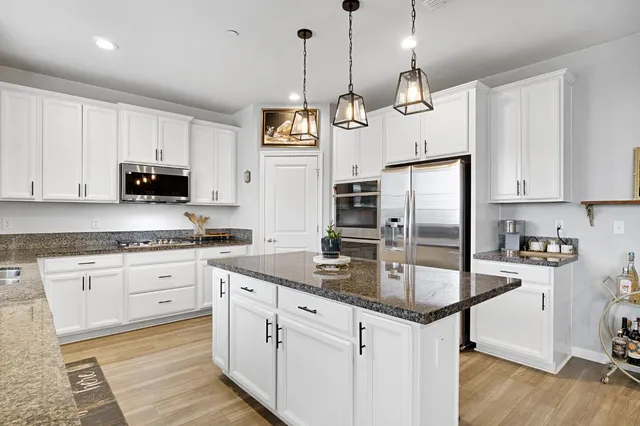 a kitchen with granite countertop a sink a stove and cabinets