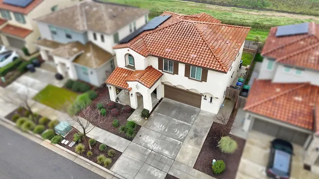 an aerial view of a city with lots of residential buildings ocean and mountain view in back
