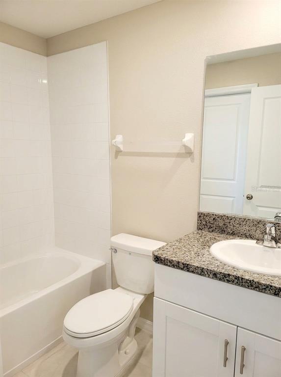 14308 Easy Goer Street Ruskin, FL 33573 - Photo 9 of 14 a bathroom with a granite countertop sink toilet and shower
